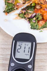 Glucose meter for sugar level control and piece of vegetarian pizza. Nutrition and eating fast food during diabetes