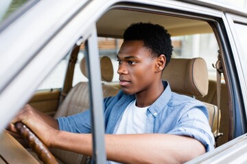 Young Black Man Driving a Vintage Car - Focus on Driver