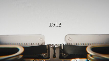 Old mechanical typewriter typing Year 1913 in a close-up view, with metal letters striking the white paper.