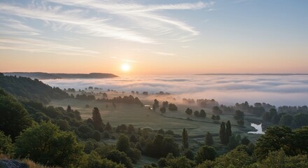 Fototapeta premium Sun illuminates extensive low-lying fog covering a valley floor at dawn