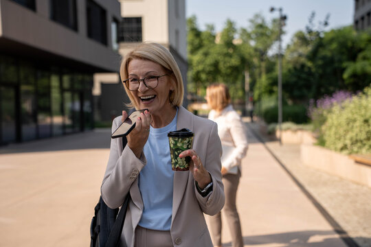 Businesswoman walking outdoors and talking on mobile phone
