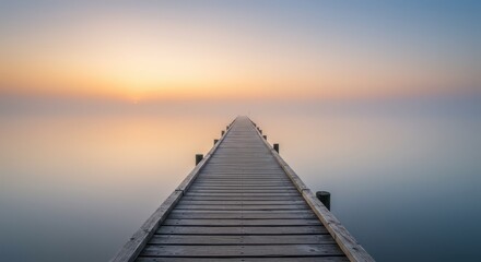 Wooden walkway stretches toward a misty horizon during soft sunrise illumination