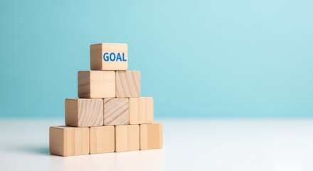 Wooden blocks stacked to form a pyramid with the word goal on top block