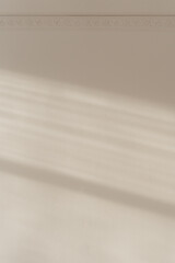 Minimalistic wall with soft shadows and light beams, peaceful ambiance, copy space. The sun shining through the wall.
