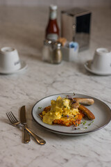 sausage and rosti with scrambled eggs on plate