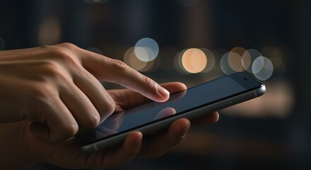Person using a mobile phone at night with bokeh lights