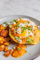 huevos rancheros with roasted potatoes on plate