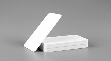 Two white rectangular objects one standing upright and one lying down on a gray background