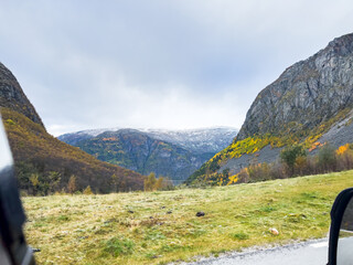 Beautiful autumn foliage and snow-capped mountains on a scenic drive in norway