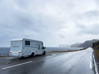 Camper van traveling on the e69 road to nordkapp, norway, on a rainy and foggy day