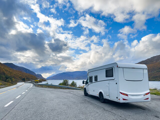 A motorhome parked by the road in the autumn landscape of the Lyngen Alps, Northern Norway, with mountains.