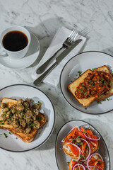 coffee with trio of gourmet toasts on marble table in hard light