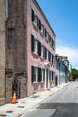 Historic pastel townhouse fa&ccedil;ade on a quiet street in Charleston, South Carolina