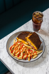 grilled cheese sandwich with meat on rye and crinkle-cut fries in diner