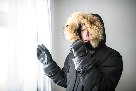 Indoor shot of sad upset Caucasian man wearing winter coat
