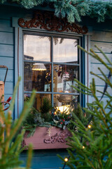 Cozy Christmas Market Stall Window Decorated with Festive Lights Ornaments and Pine Branches