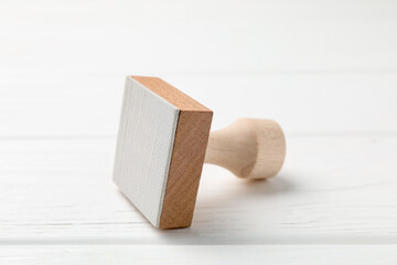 One wooden stamp on white table, closeup