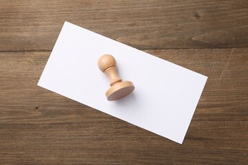One wooden stamp and blank sheet of paper on table, top view. Space for text