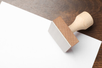 One wooden stamp and blank sheet of paper on table, top view. Space for text