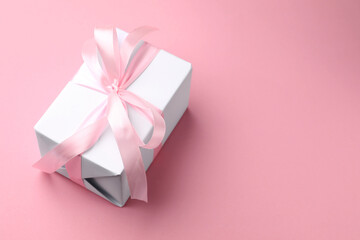 Beautiful gift box on pink background, closeup. Space for text