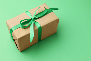 Beautiful gift box on green background, closeup. Space for text