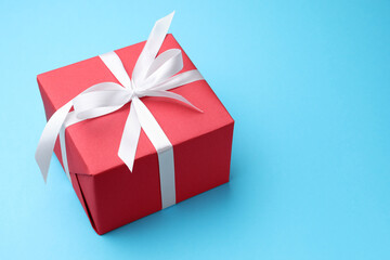 Beautiful gift box on light blue background, closeup. Space for text