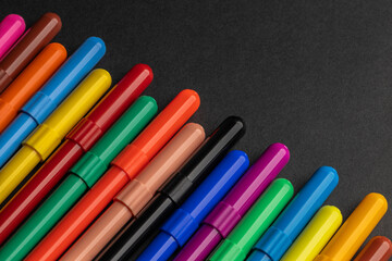 many colorful felt-tip pens on a black background
