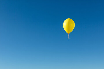 Obraz premium Yellow balloonon blue sky. Minimal concept.