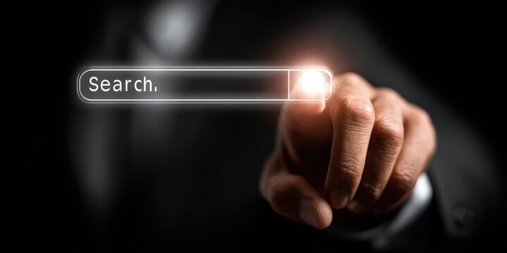 A man is pointing at a search bar on a computer screen