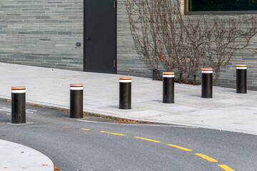 Modern Retractable Security Bollards on Urban Sidewalk at Building Entrance