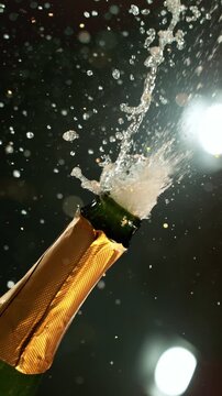 Super slow motion of Champagne explosion with flying cork closure, opening champagne bottle closeup, camera movement. Filmed on high speed cinematic camera at 1000 frames per second.