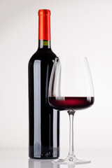 Naklejka premium Red wine bottle and glass on white background