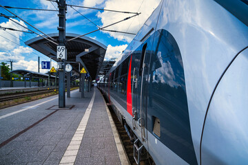 Refined locomotive at platform, contemporary transportation scene with passengers and signage present