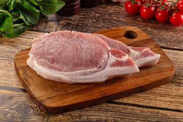 Raw pork steak over board