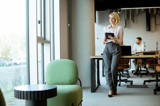 Business professional engaged in work while standing in modern office space