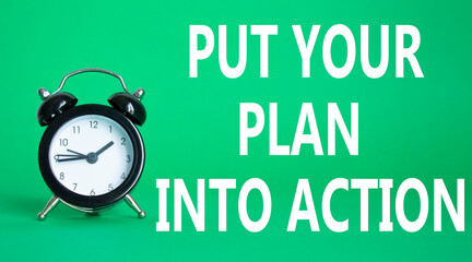 Put your plan into action symbol. Concept words Put your plan into action on white puzzle. Beautiful green background with alarm clock. Business concept and Put your plan into action. Copy space.