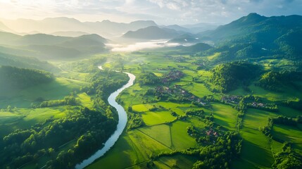 Lush green valley with winding river and distant mountains Photo