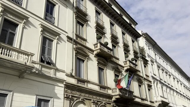 The Museo Italiano Arte displays its classical entrance along Via Principe Amedeo in Milan. The flags above the door add formality and signify its cultural status.