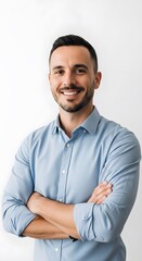 Portrait of one handsome young businessman standing and smiling confidently in a studio, arms crossed