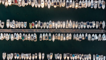 Abstract aerial view of boats moored in the historic port of Koper, Slovenia. Top-down view of the vessels neatly arranged in the water