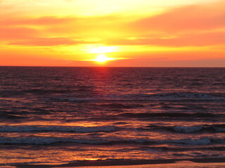 Vivid Orange Sunset Over Calm Ocean Waves