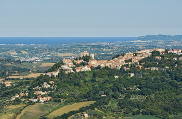 Elevated view of the hill town of Verucchio, Italy, overlooking rolling hills and the Adriatic Sea.