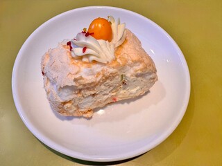 juicy and delicious dessert meringue roll decorated with fezalis on a white porcelain plate. High quality photo