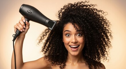 Happy woman with curly hair using a hairdryer. Surprised model styling her natural afro texture hair with a blow dryer. Beauty and hair care routine concept