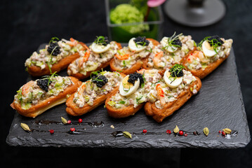 A delectable arrangement of eclairs filled with a savory mix, topped with sliced eggs, greens, and caviar. perfect for elegant gatherings and special events.