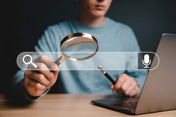 Person holding magnifying glass over search bar with laptop representing online search information retrieval and data analysis for research and investigation on the internet and web