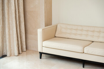 Elegant beige sofa in minimalist room, offers a cozy seating option in a minimalist room. the elegant design complements the neutral tones and soft textures of the surroundings, creating a peaceful am