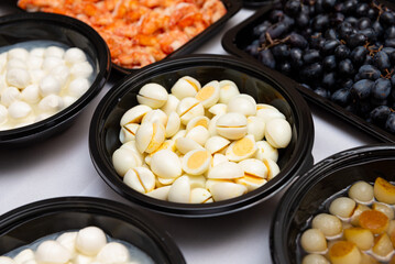 A diverse platter featuring bowls of fresh ingredients like eggs, shrimp, grapes, and more. perfect for showcasing the abundance and variety of a buffet or catering event.