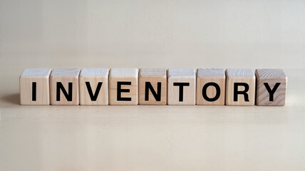 Wooden blocks spelling inventory on a light wood surface ideal for business finance and supply chain management content showcasing organization and stock control for retail and ecommerce