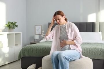 Obraz premium Pregnant woman suffering from nausea in bedroom. Space for text